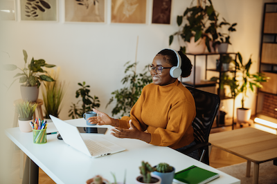woman sitting at computer listening to webinar
