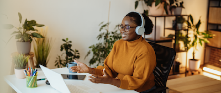 woman sitting at computer listening to webinar